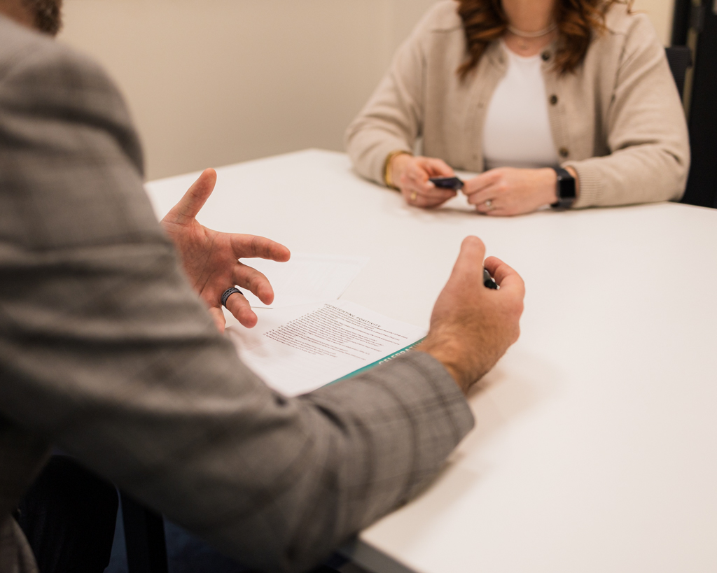 Man and woman sitting across from each other at a boardroom table